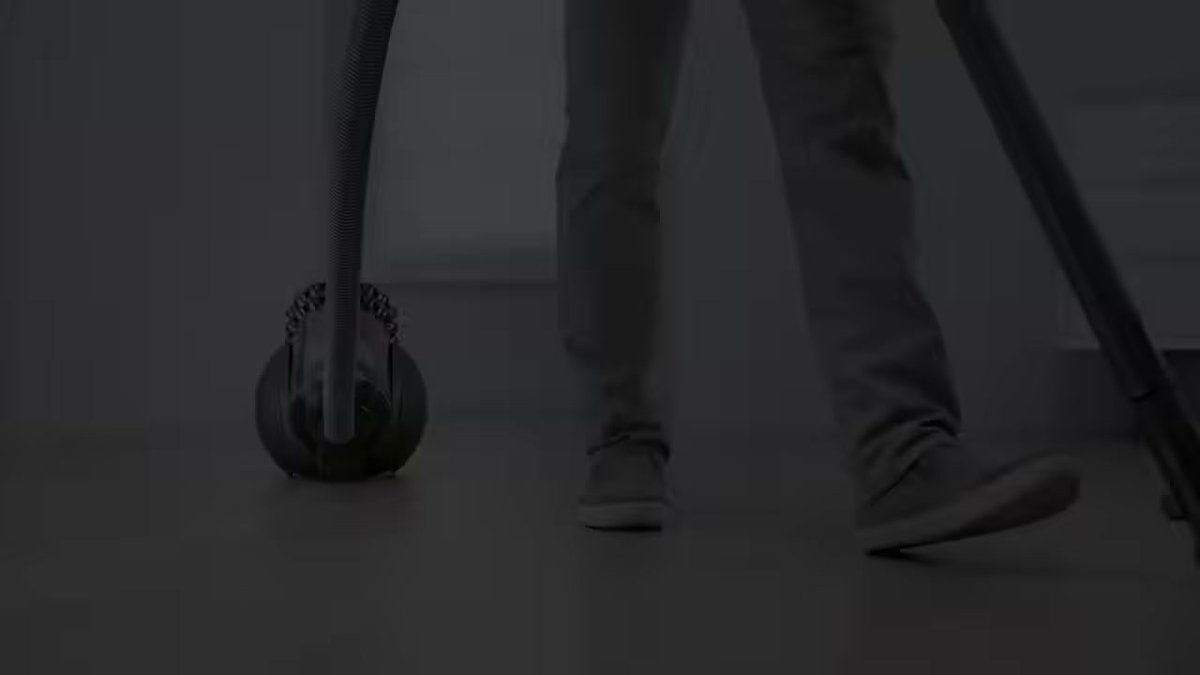 Dyson Big Ball Multi Floor Canister being used on hardwood floor with person walking alongside