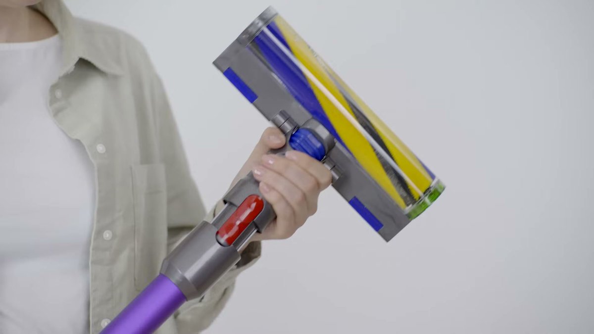 Person holding Dyson Gen5detect vacuum with visible brush roll and purple handle