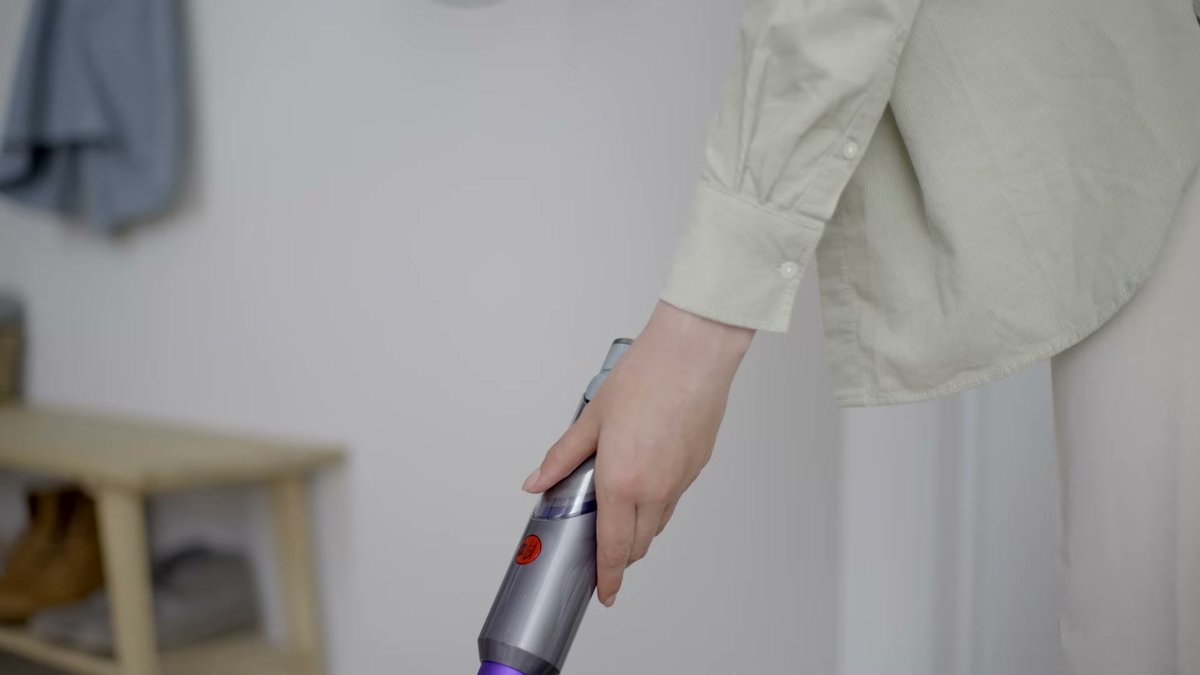Person holding Dyson Gen5detect vacuum in a home setting